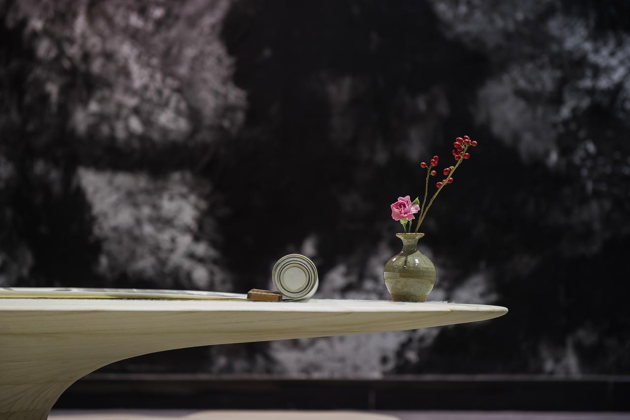 The Emperor Tiananmen Beijing Hotel Bagian luar foto A table with a vase of flowers